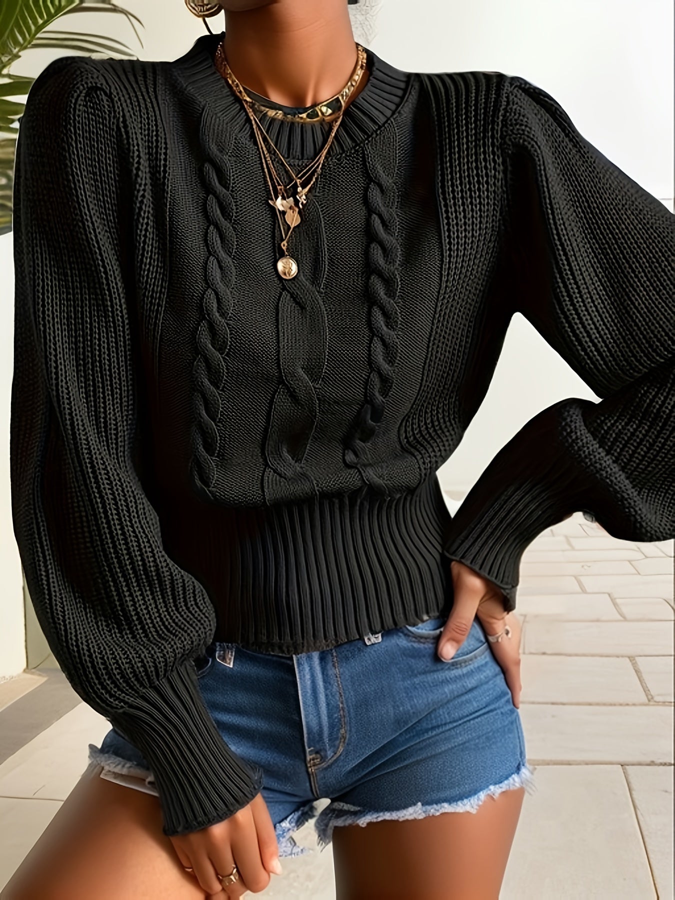 Pull noir à col rond et motif torsadé