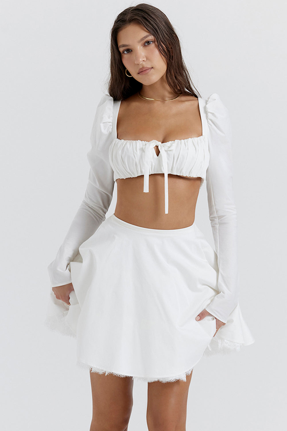 Top blanc à manches bouffantes et mini jupe avec nàud