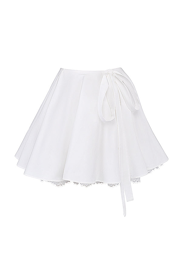 Top blanc à manches bouffantes et mini jupe avec nàud