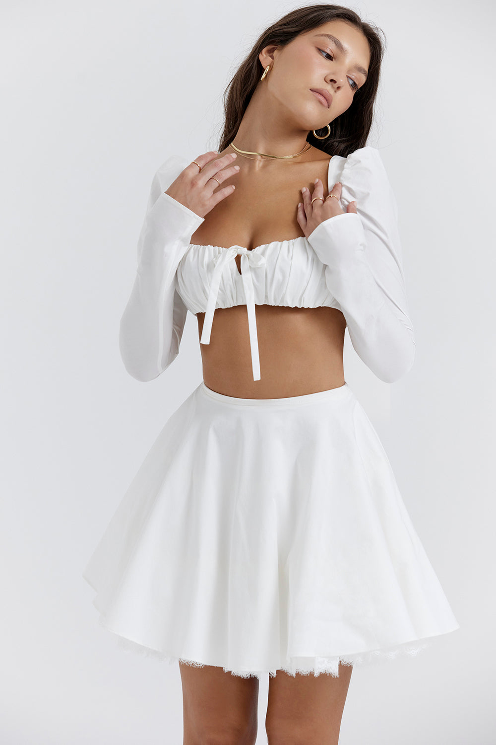 Top blanc à manches bouffantes et mini jupe avec nàud