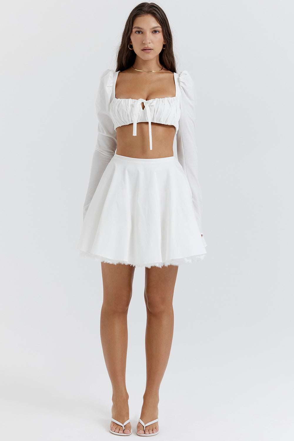 Top blanc à manches bouffantes et mini jupe avec nàud